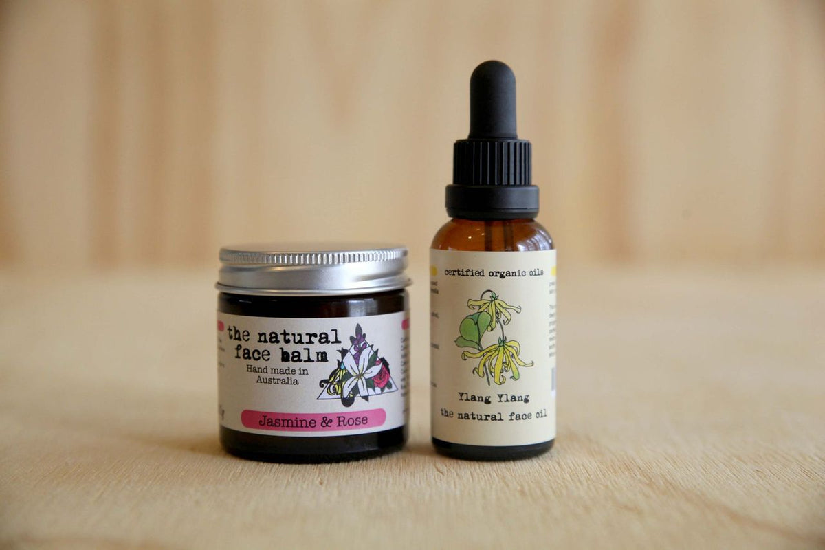 Two the natural deodorant skincare products the natural face balm and the natural face oil on a wooden surface