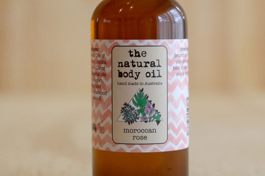 Bottle of natural body oil with a label on a blurred background