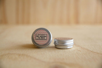 The natural lip balm in a tin on a plywood background.