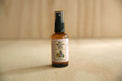 Bottle of 'The Natural Face Mist' on a wooden surface with a neutral background