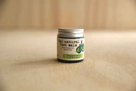Jar of 'The Natural Foot Balm' on a wooden surface